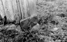 A fragment of a barns wall and a stone foundation