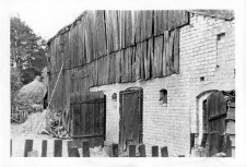 A frame-planks barn connected with a brick cowshed