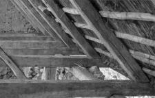 A rafters setting on beams in an old brick barn